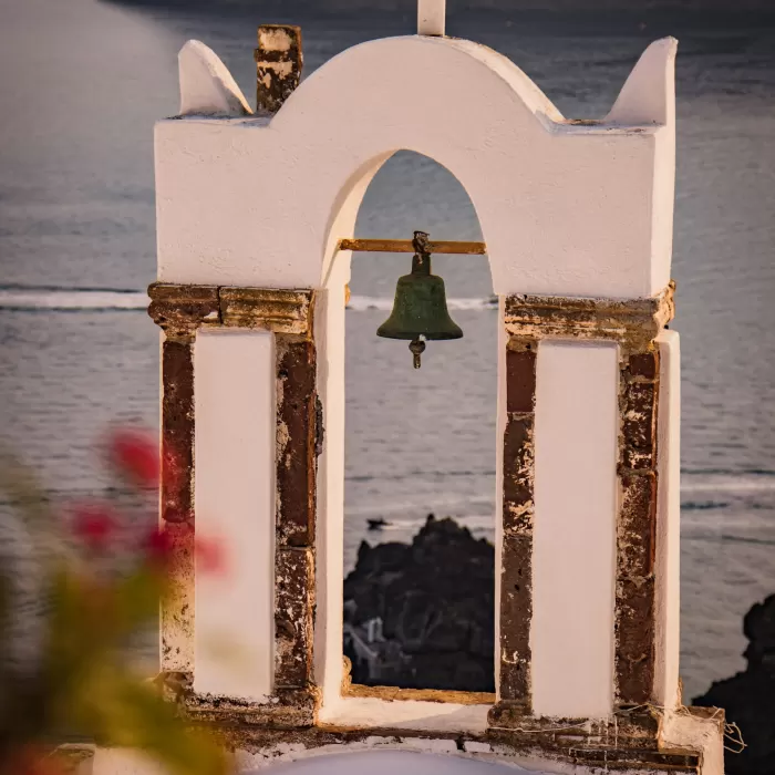 White Cycladic bell tower by the sea