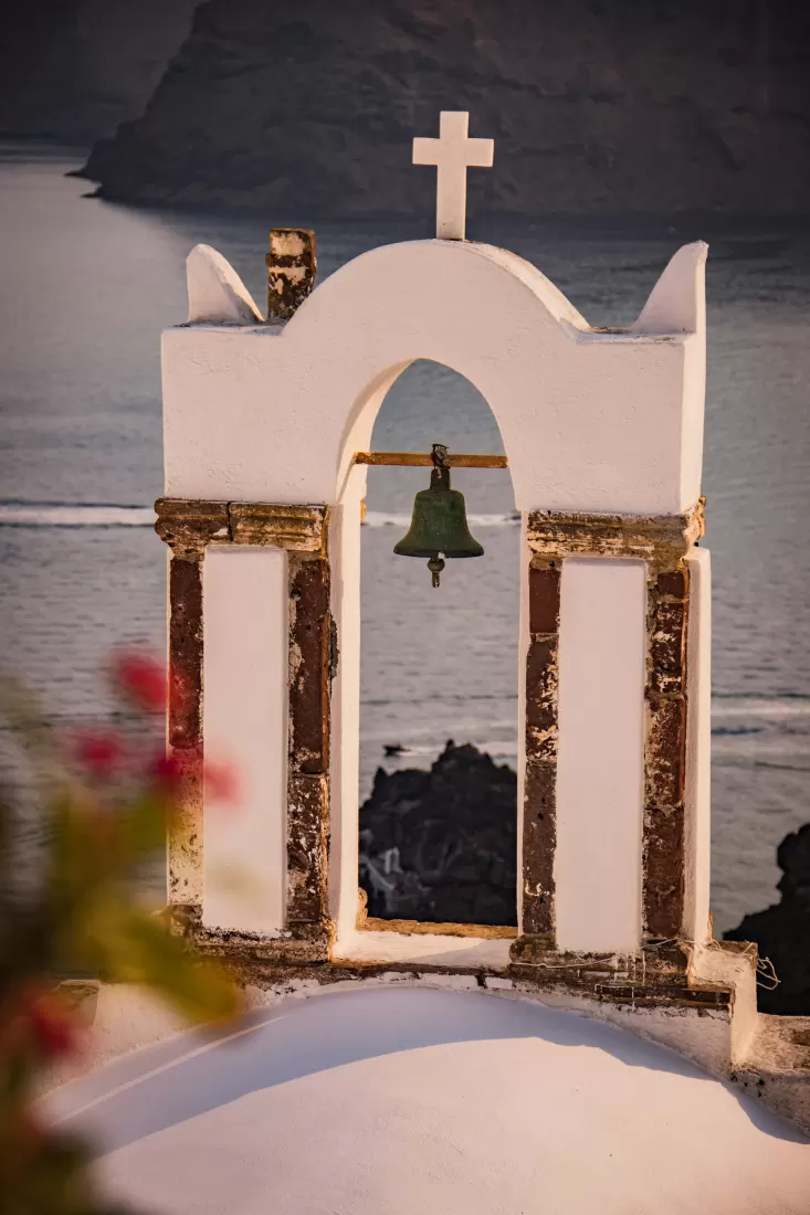 White Cycladic bell tower by the sea